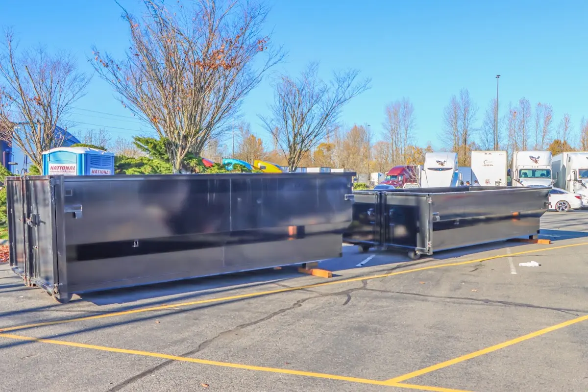 Professional dumpster rental service with roll-off container on residential driveway in South Hill